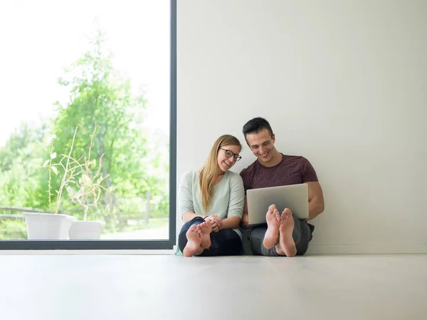 Couple using laptop on the floor at home — Stock Photo, Image