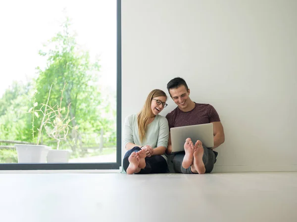 Pareja usando el ordenador portátil en el suelo en casa —  Fotos de Stock