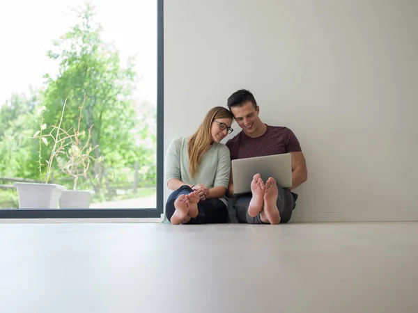 夫妇在家里的地板上使用笔记本电脑 — 图库照片