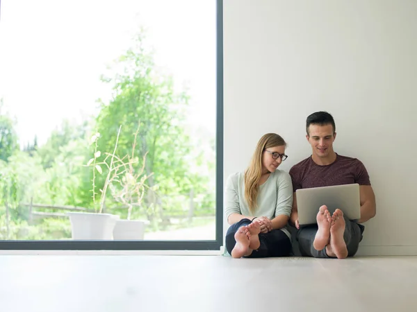 Couple utilisant un ordinateur portable sur le sol à la maison — Photo