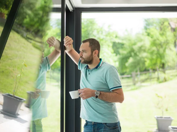 Joven bebiendo café de la mañana junto a la ventana — Foto de Stock