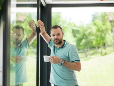 pencerenin yanında içme sabah kahvesi genç adam
