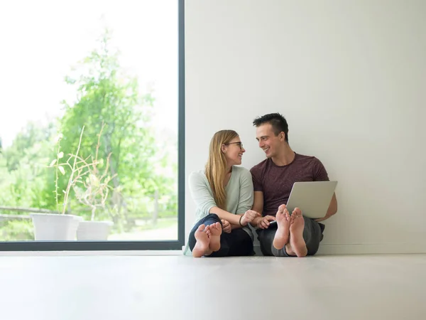 Couple utilisant un ordinateur portable sur le sol à la maison — Photo