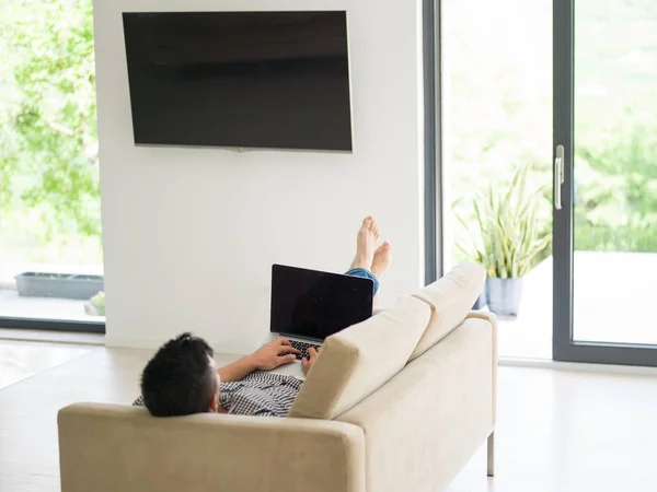 Hombre usando el portátil en la sala de estar — Foto de Stock