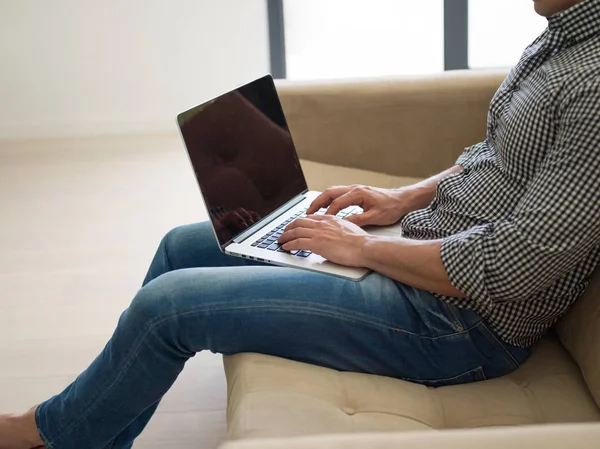 Laptopot használó férfi a nappaliban — Stock Fotó