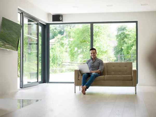 Man met laptop in de woonkamer — Stockfoto