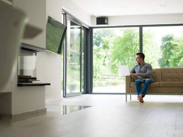 Man met laptop in de woonkamer — Stockfoto