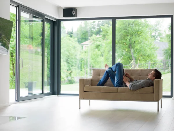 Man on sofa using tablet computer — Stock Photo, Image