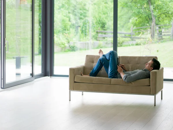 Mann auf Sofa mit Tablet-Computer — Stockfoto