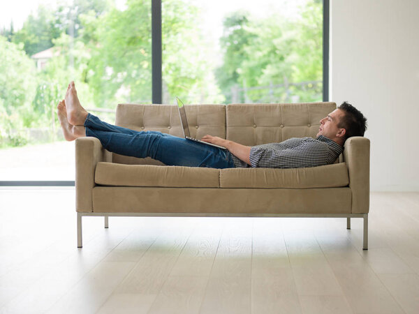 Человек с ноутбуком в гостиной