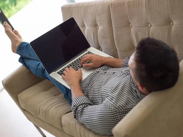 Людина використовує ноутбук у вітальні — стокове фото