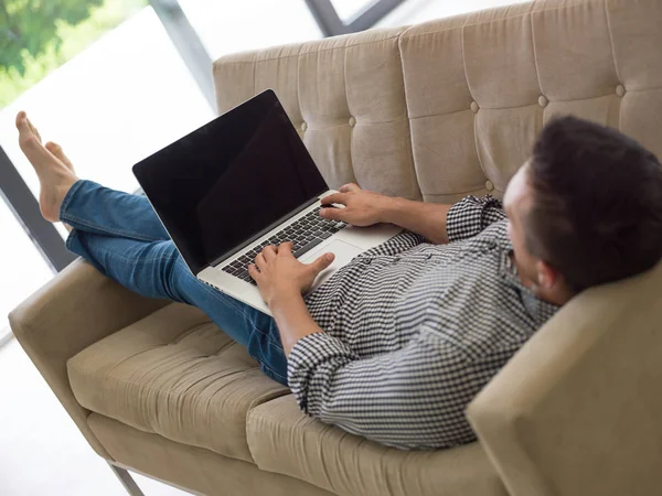 Man using laptop in living room — Stock Photo, Image