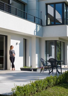 lüks ev önünde tablet bilgisayar kullanan kadın 