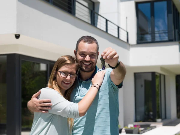 Couple hugging in front of new luxury home — Stock Photo, Image