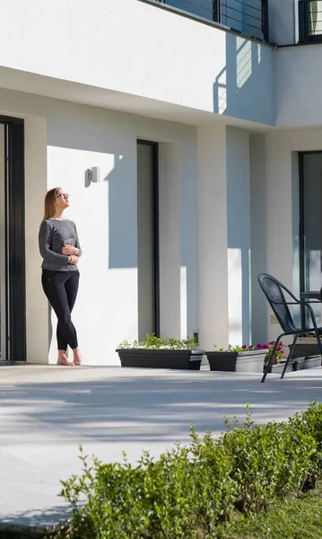 Vrouw met behulp van tablet pc voor luxehuis — Stockfoto