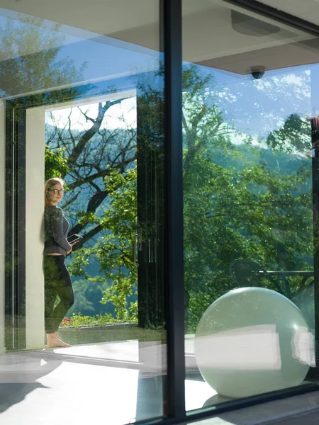 Woman using tablet computer in front of luxury home — Stock Photo, Image