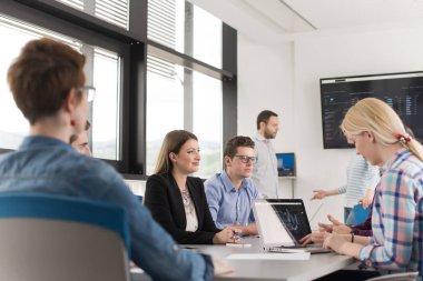 Bir grup iş adamı ofiste iş planlarını tartışıyor.