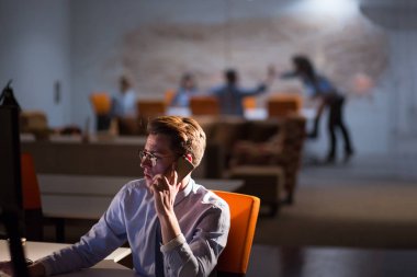 karanlık ofisinde cep telefonu kullanan adam