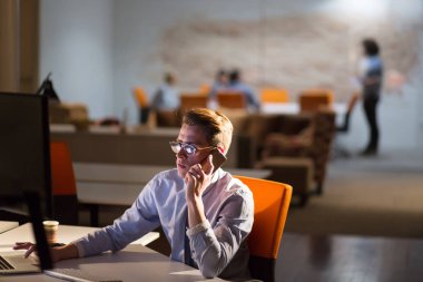 karanlık ofisinde cep telefonu kullanan adam