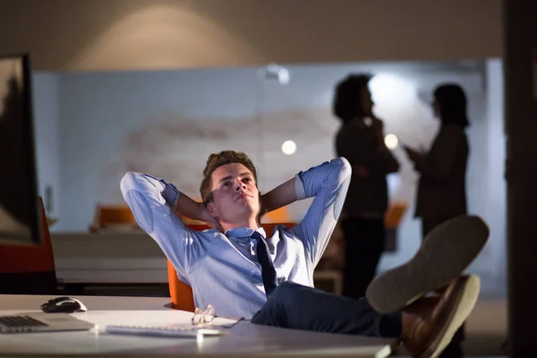 Affärsman som sitter med benen på skrivbord på kontoret — Stockfoto