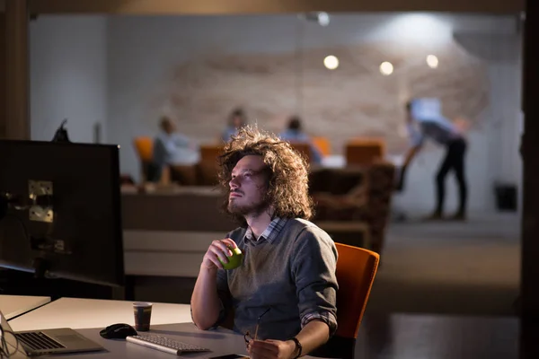 Uomo che lavora al computer in ufficio buio — Foto Stock