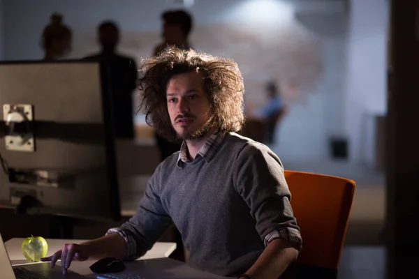 Uomo che lavora al computer in ufficio buio — Foto Stock