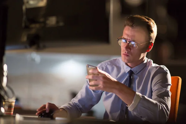 Hombre usando el teléfono móvil en la oficina oscura — Foto de Stock