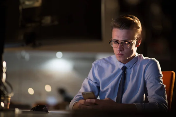 Homme utilisant un téléphone portable dans le bureau sombre — Photo