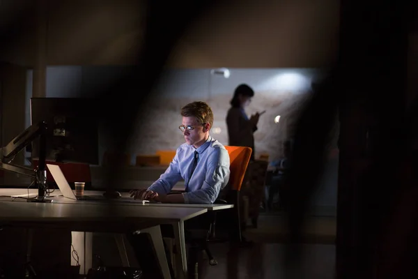 Karanlık ofisinde bilgisayarda çalışan adam — Stok fotoğraf