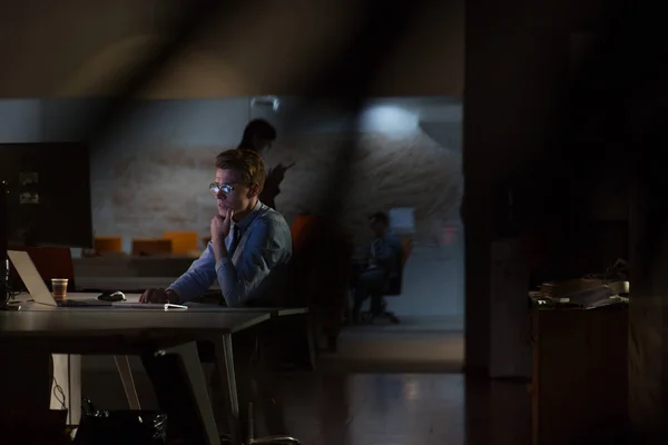 Hombre trabajando en la computadora en la oficina oscura — Foto de Stock