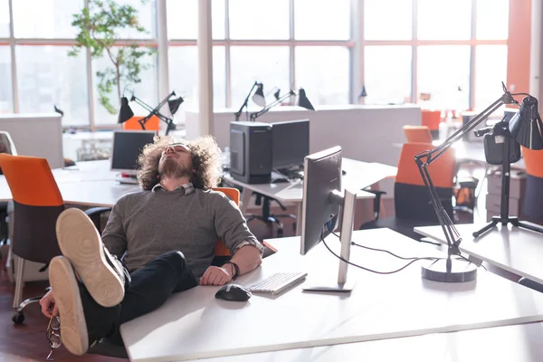 Homme d'affaires assis avec les jambes sur le bureau — Photo