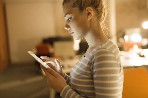 Mujer trabajando en tableta digital en la oficina nocturna — Foto de Stock