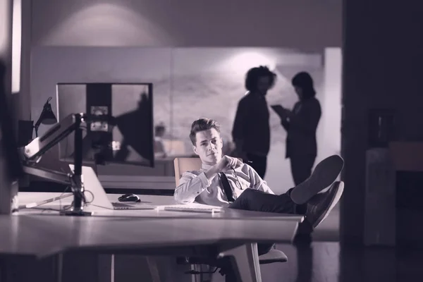 Hombre de negocios sentado con las piernas en el escritorio en la oficina — Foto de Stock
