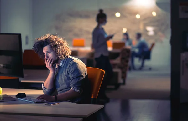 Mann arbeitet im dunklen Büro am Computer — Stockfoto