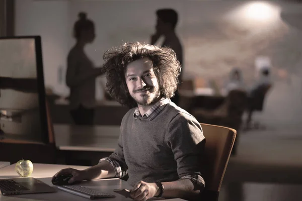 Man aan het werk op computer in donkere kantoor — Stockfoto