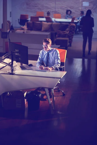Hombre trabajando en la computadora en la oficina oscura —  Fotos de Stock