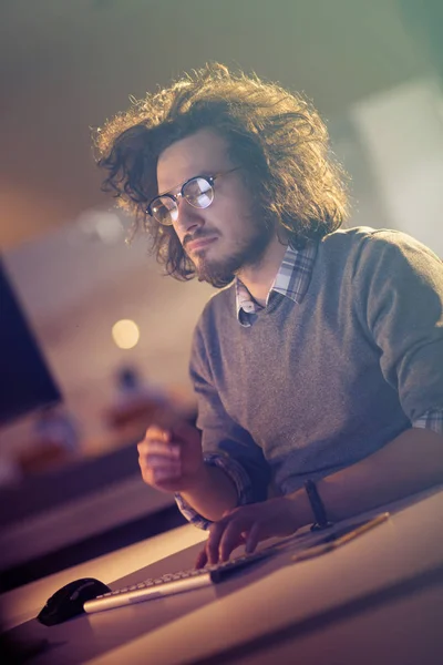 Mann arbeitet im dunklen Büro am Computer — Stockfoto