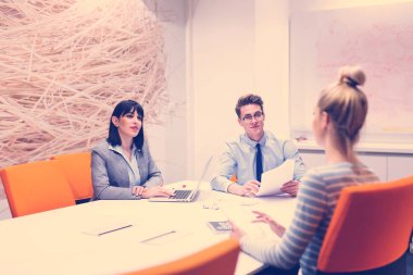 Bir grup iş adamı ofiste iş planlarını tartışıyor.