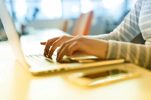 Businesswoman using a laptop in startup office — Stock Photo, Image