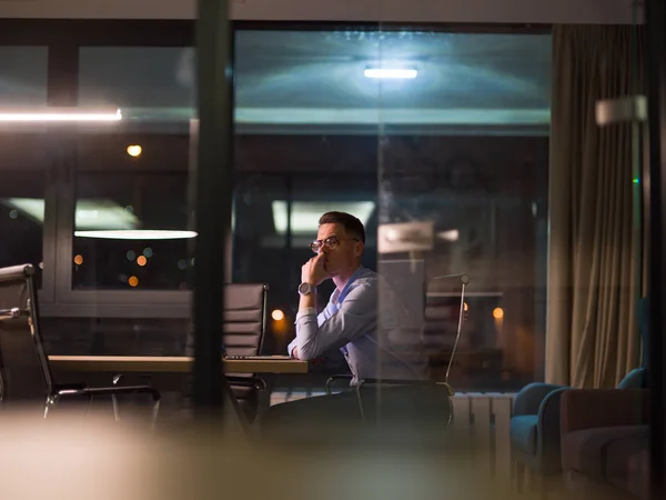 Homme travaillant sur ordinateur portable dans le bureau sombre — Photo
