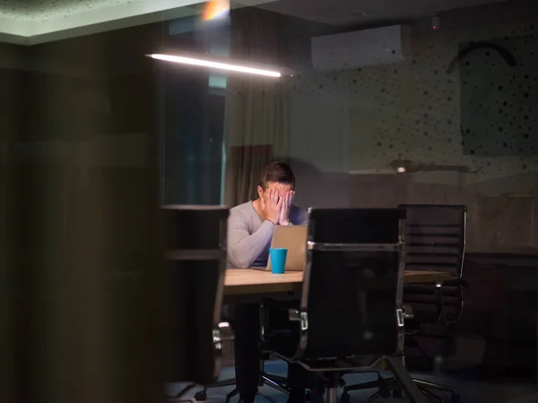 Hombre trabajando en el ordenador portátil en la oficina oscura —  Fotos de Stock