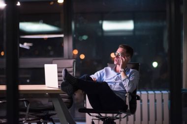 cep telefonuyla karanlık ofisinde işadamı