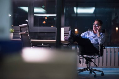 cep telefonuyla karanlık ofisinde işadamı