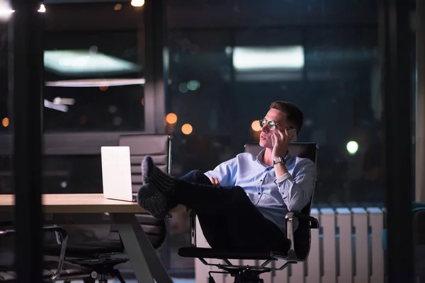 Homem de negócios usando telefone celular no escritório escuro — Fotografia de Stock