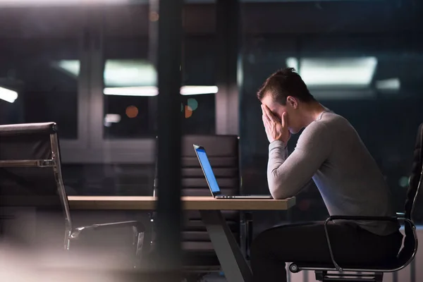 Man som arbetar på laptop i mörka office — Stockfoto