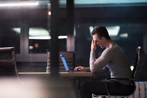 Man som arbetar på laptop i mörka office — Stockfoto