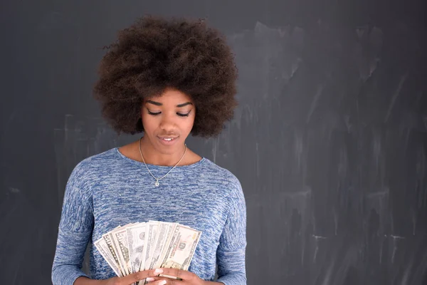 Μαύρη γυναίκα που κρατά χρήματα σε γκρίζο φόντο — Φωτογραφία Αρχείου
