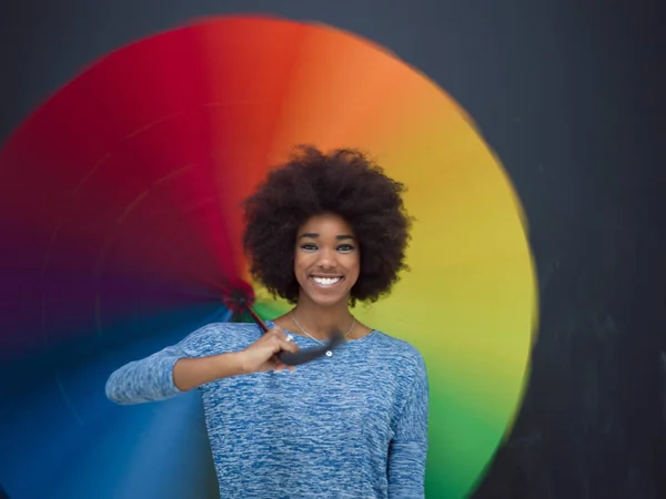 Africano americano mulher segurando um guarda-chuva colorido — Fotografia de Stock