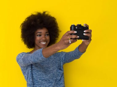 Genç Afro-Amerikan kız alarak resmi retro bir fotoğraf makinesi için