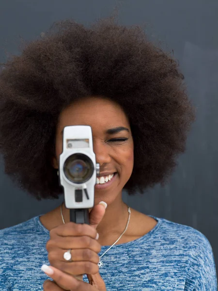 African american woman using a retro video camera — Stok Foto